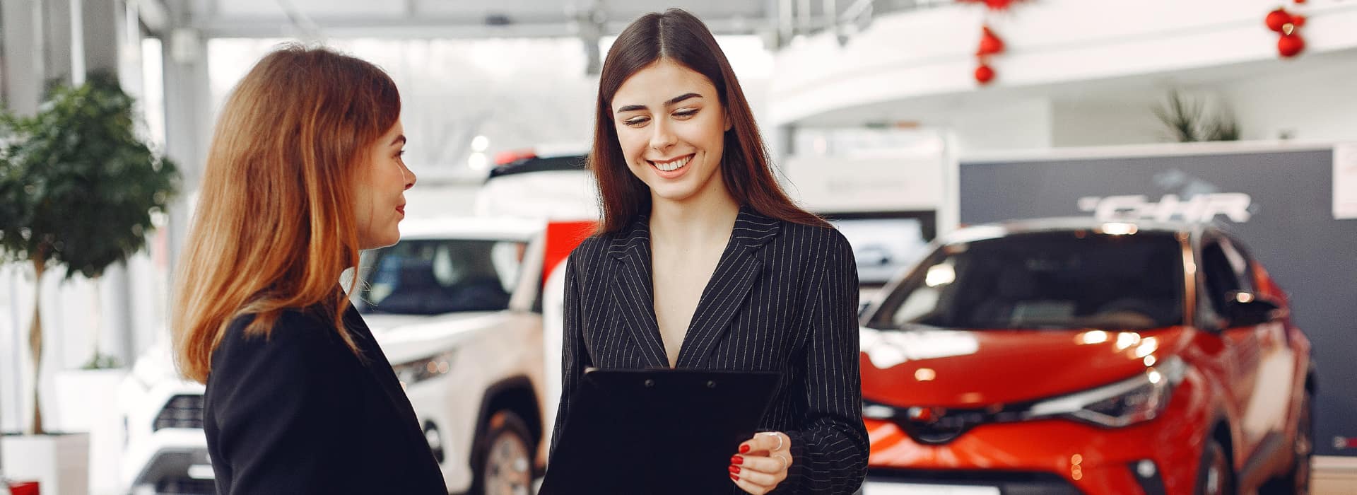Saleswoman at dealership with happy client