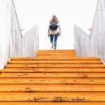 Female walking up trainline stairs with backpack