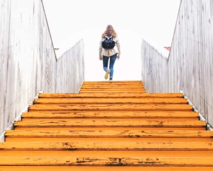 Female walking up trainline stairs with backpack