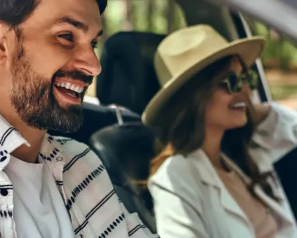 Happy man and lady cruising in car