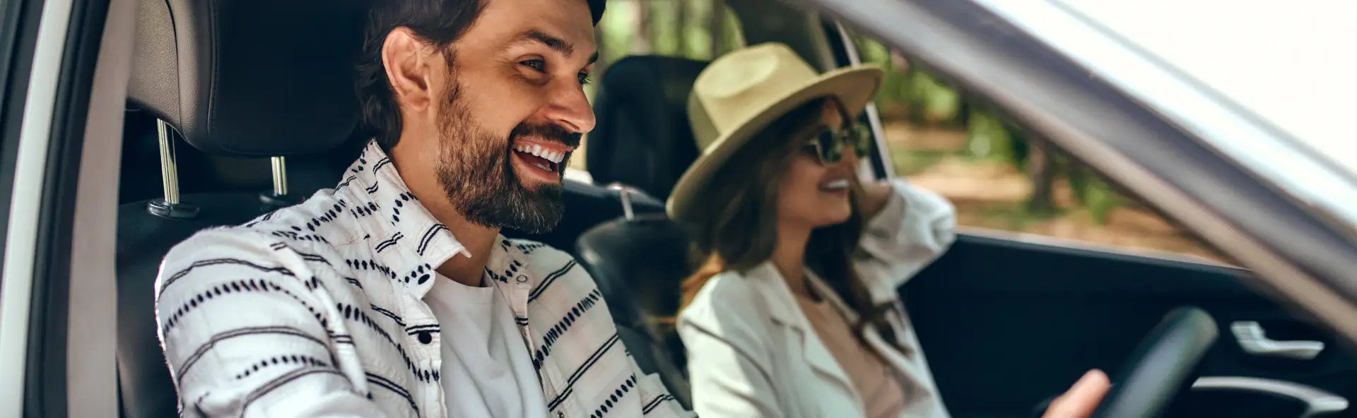 Happy man and lady cruising in car