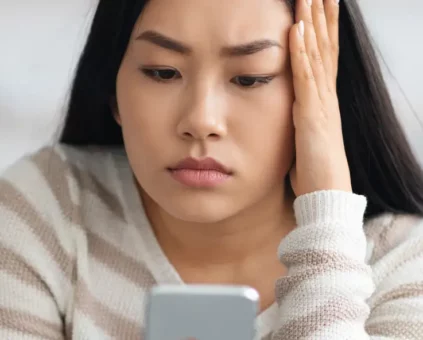 Young female confused looking at mobile