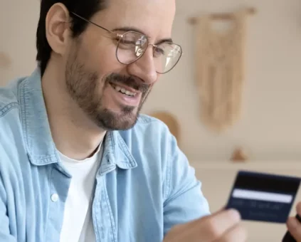 Man smiling and making purchase with credit card on phone