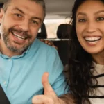 Happy couple driving in car