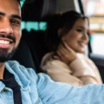 Young couple driving away in new car