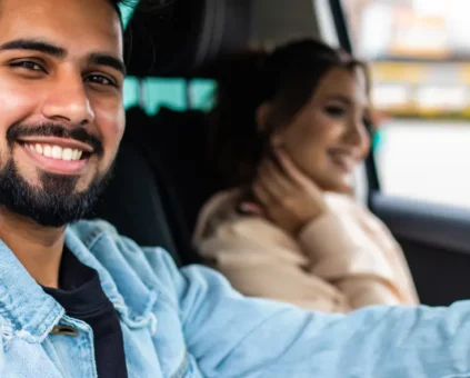 Young couple driving away in new car