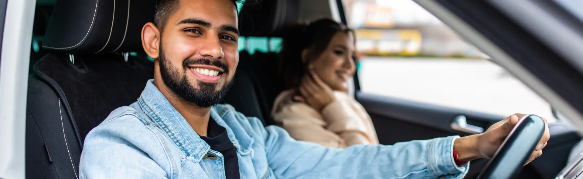 Young couple driving away in new car