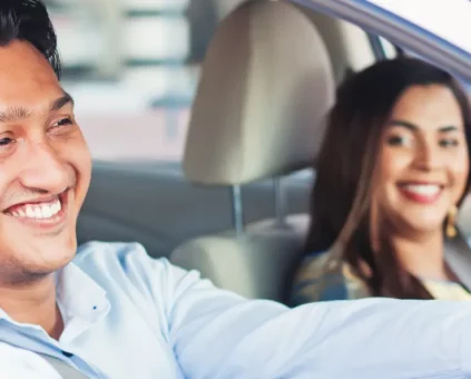 Couple smiling and driving in sedan