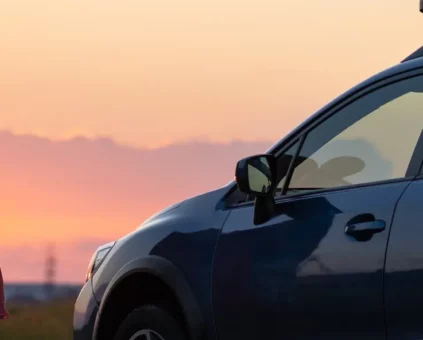 Couple admiring sunset next to new car