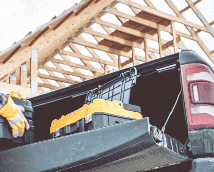 Construction worker at their work site loading tools into their pickup truck from their bad credit business car loan settlement with Ume Loans