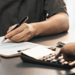 Signing bad credit car loan agreement with lender and toy car on desk